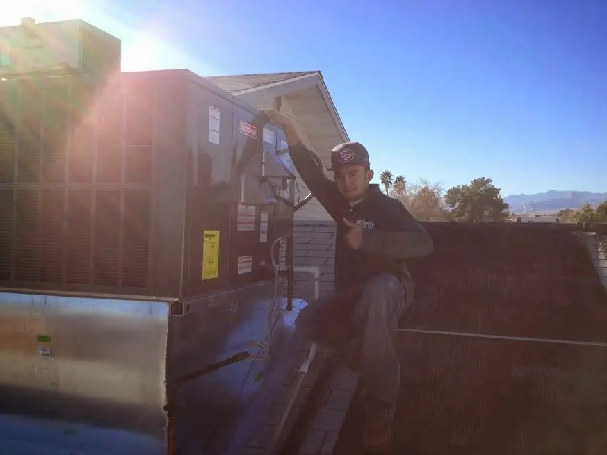 HVAC technician performing AC Tune-Up on a rooftop unit in Sienna
